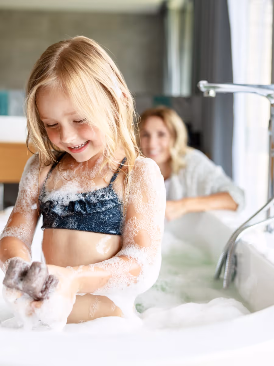 Kind wäscht sich in einem modernen Badezimmer in der Badewanne.