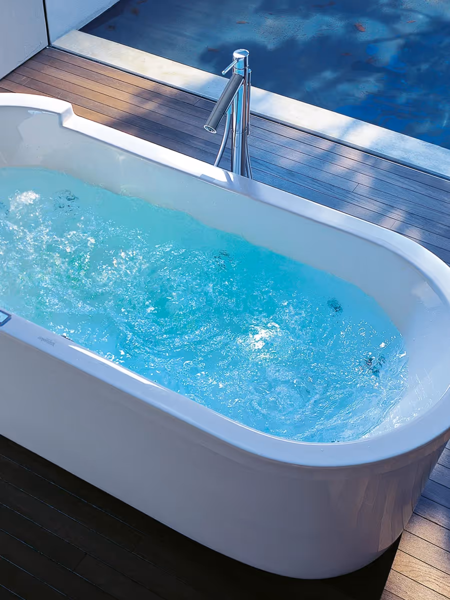Freistehende Badewanne mit Wasserfunktion in einem modernen Badezimmer.