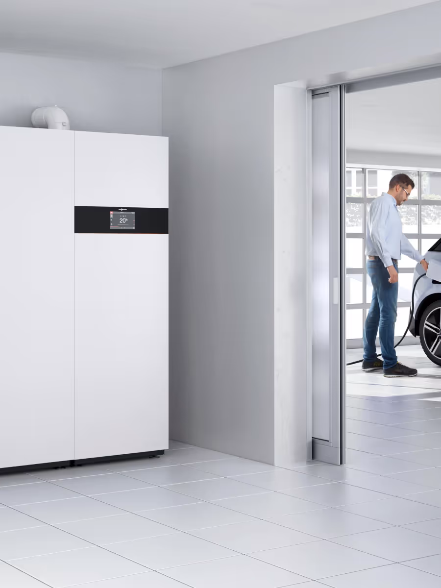 Moderne Haustechnikanlage neben einer Garage mit Elektroauto.