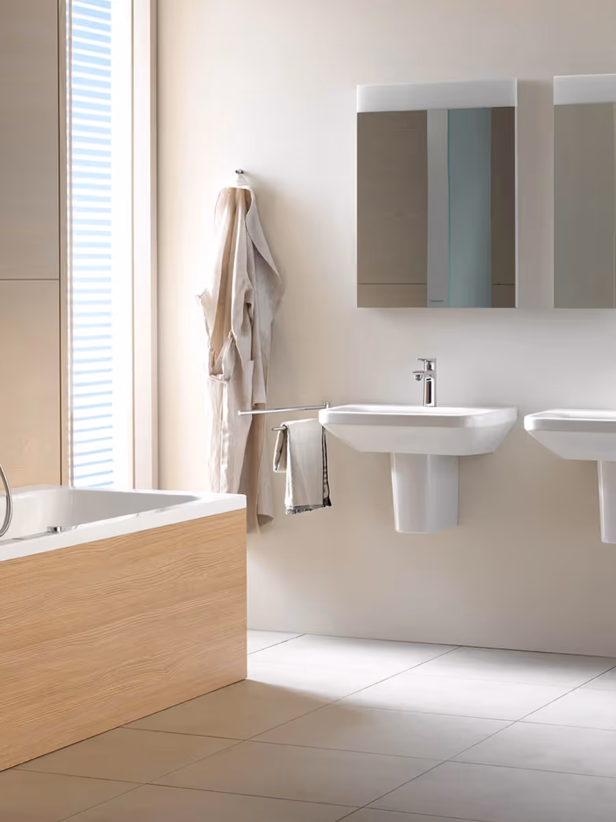 Helles Badezimmer mit Badewanne, zwei Waschbecken und Spiegelschränken.