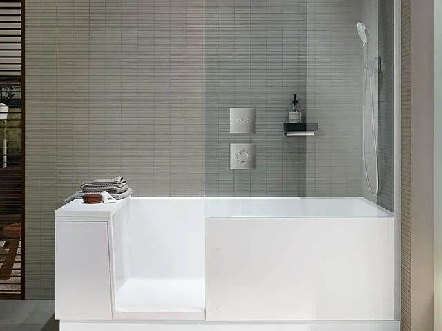 Badewannen-Duschkombination mit Glasabtrennung und Wandbrause.