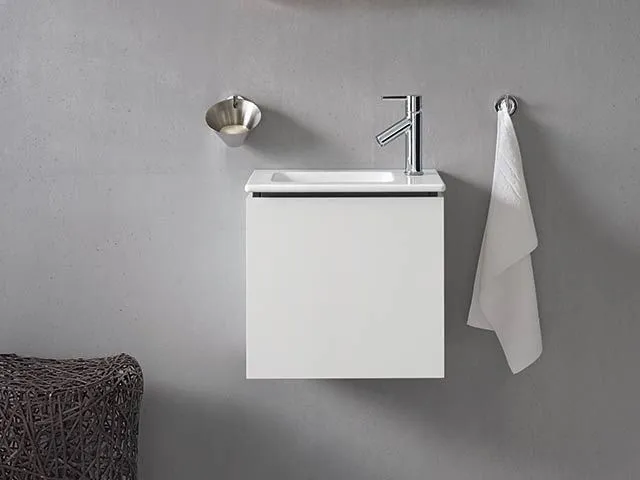 Kompakter wandhängender Gäste-WC-Waschtisch mit weißem Unterschrank und verchromter Einhebelmischer-Armatur.