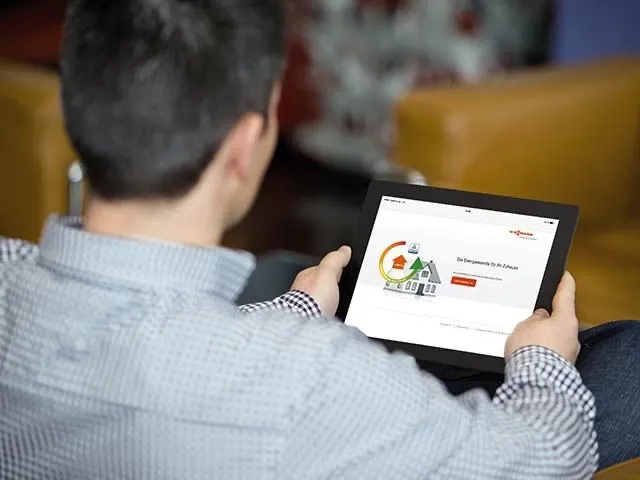 Mann betrachtet auf einem Tablet einen Online-Energierechner für die neue Heizung.