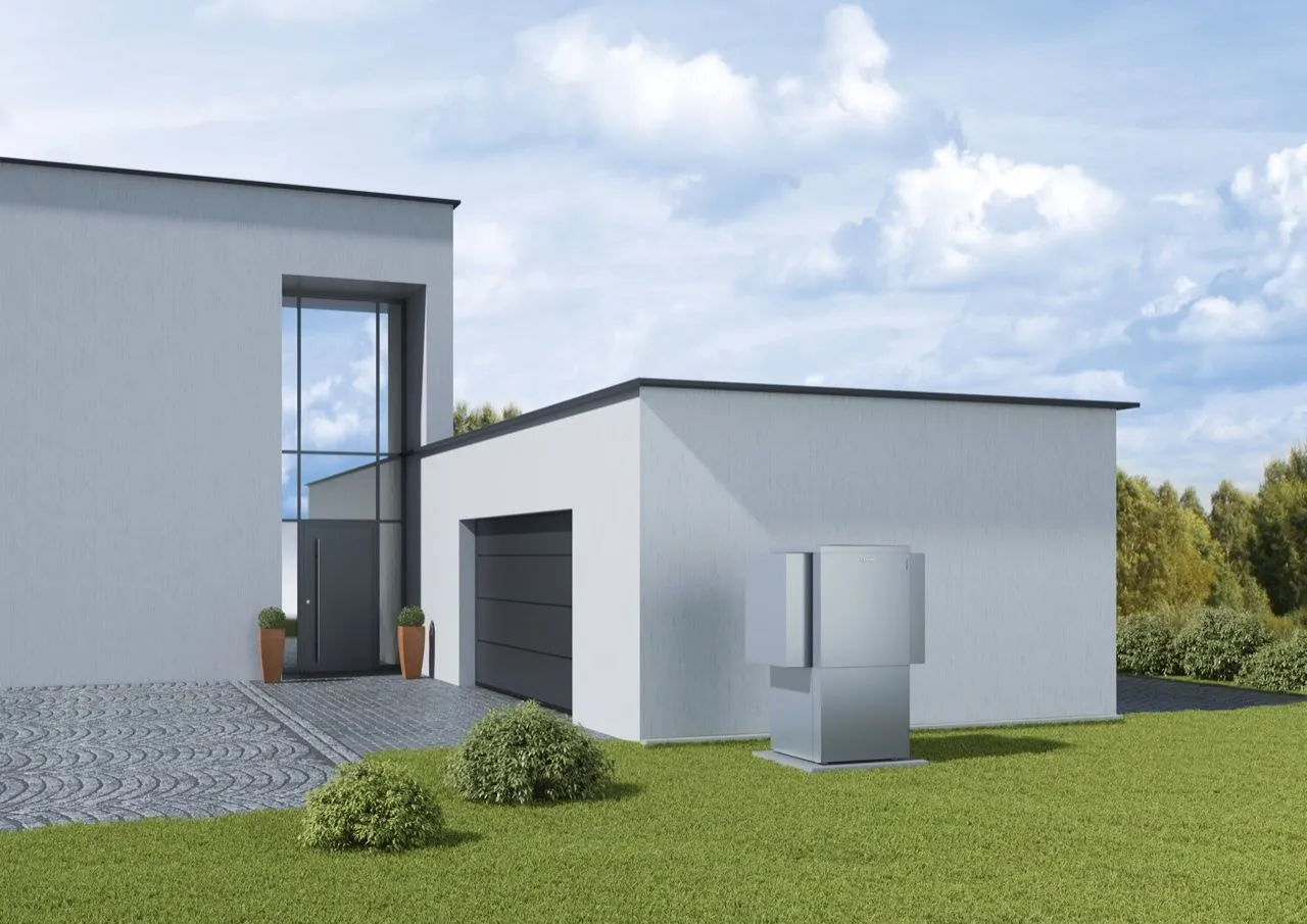 Wärmepumpen-Außeneinheit im Garten eines modernen Architektenhauses.