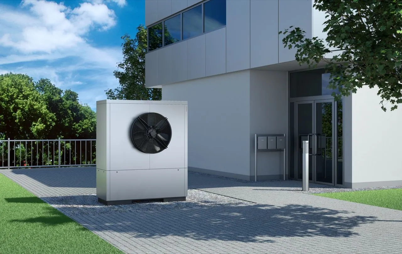Leistungsstarke Luft-Wärmepumpe vor dem Eingang eines modernen Geschäftsgebäudes.