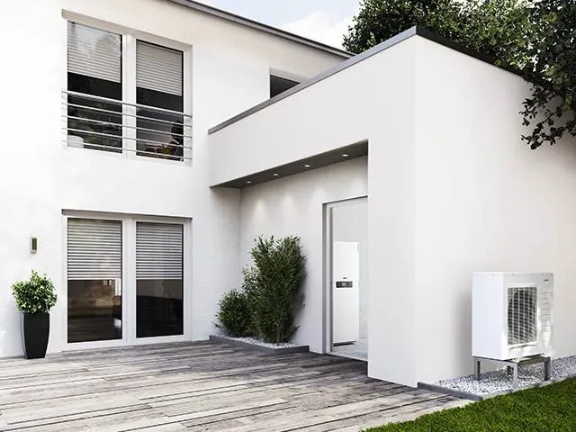 Außengerät einer Wärmepumpe an einem modernisierten Wohnhaus.